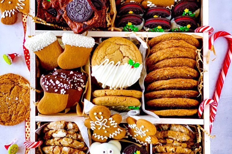 A delicious and festive cookie dessert box with gingerbread men, stockings, and sweaters decorated with chocolate, Chewy maple cinnamon cookies with white chocolate, Brown butter and maple chewy pumpkin cookies, Chocolate covered Oreos, Chewy Oreo Brownies, and Gingerbread Crinkle Cookies