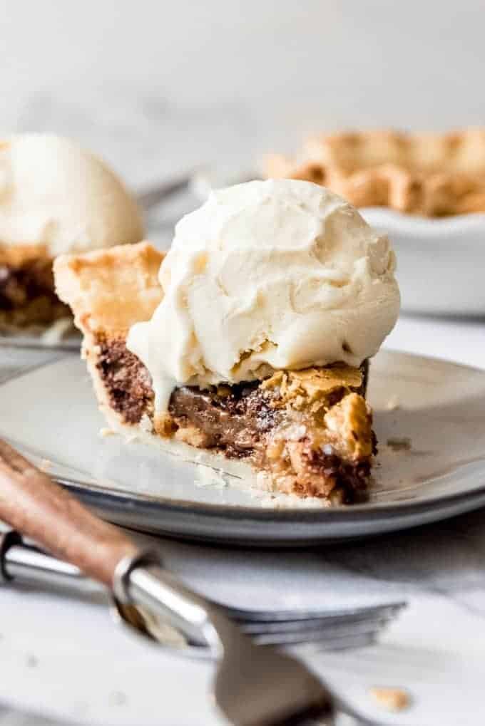 A slice of Kentucky Derby Day Pie with a scoop of vanilla ice cream melting on top.