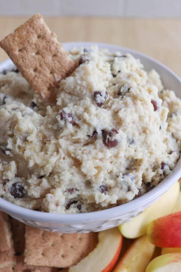 Cottage cheese cookie dough dip in a white bowl surrounded by graham crackers and apple slices.