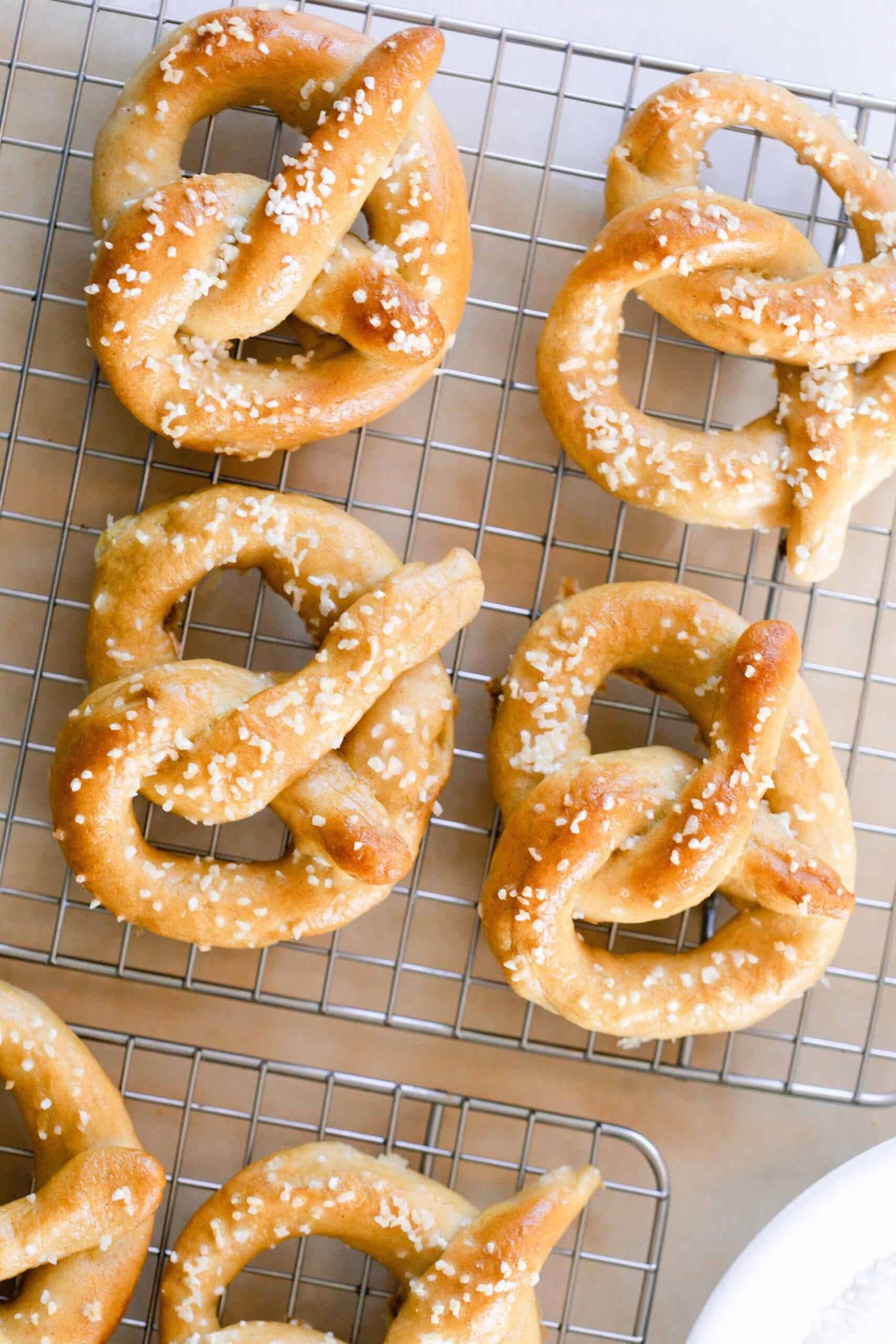overhead photo of six sourdough pretzels on a wire cooling rack.