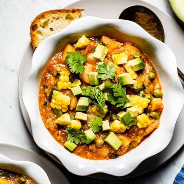 Quinoa stew in a bowl with a spoon on the side