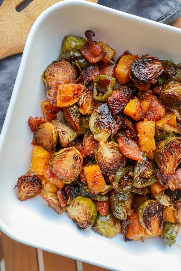 roasted Brussels sprouts with butternut squash and bacon in a large white bowl