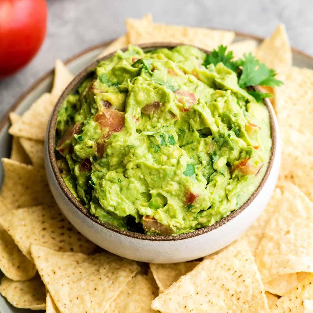 a bowl of homemade guacamole surrounded by chips